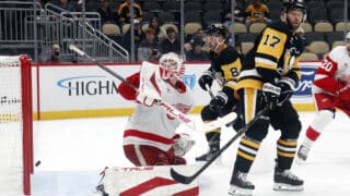 Ville Husso Detroitin maalilla torjuntatöissä lokakuussa Pittsburgh Penguinsia vastaan. Torjuu kiekon ylös oikealle kilvellä. Kuva otettu loivasti etuoikealta maalivahdista katsottuna.