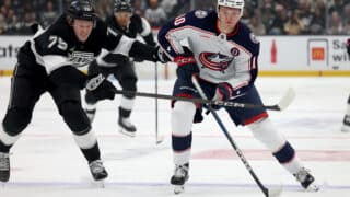 Nov 9, 2024; Los Angeles, California, USA; Columbus Blue Jackets left wing Dmitri Voronkov (10) keeps the puck from Los Angeles Kings center Samuel Helenius (79) during the third period at Crypto.com Arena. Mandatory Credit: Jason Parkhurst-Imagn Images