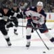 Nov 9, 2024; Los Angeles, California, USA; Columbus Blue Jackets left wing Dmitri Voronkov (10) keeps the puck from Los Angeles Kings center Samuel Helenius (79) during the third period at Crypto.com Arena. Mandatory Credit: Jason Parkhurst-Imagn Images