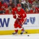 Dylan Larkin pelaamassa Detroit Red Wingsin paidassa helmikuussa. Kapteeni kuljettaa kiekkoa oikealla laidalla, katse ylhäällä.